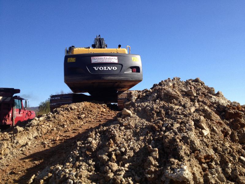 This excavator is loading unsuitable material on trucks to be hauled off the construction site.