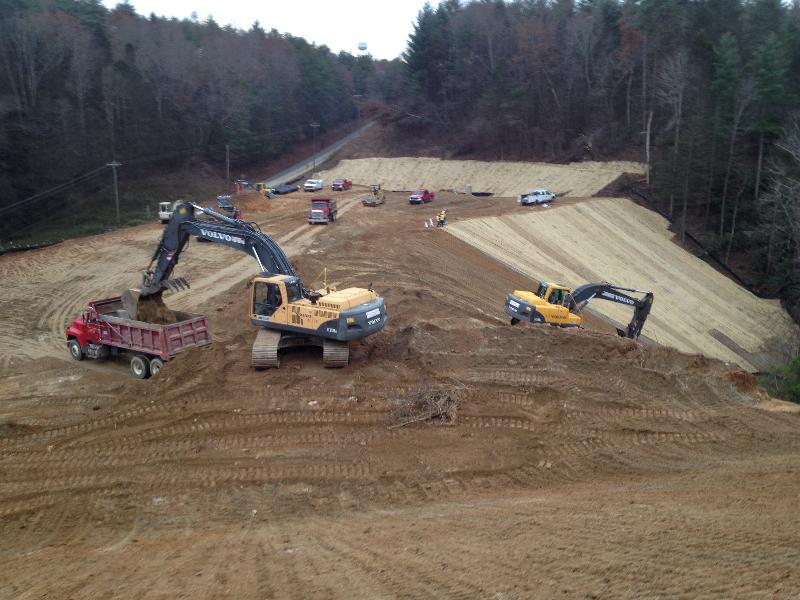 Whitmire Grading's excavator and trucks are exporting excess material off site while other phases of the project are carried out.